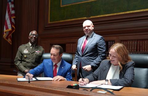 Executive Director Emily Domenech and Louisiana Governor Jeff Landry signing their MOU copies
