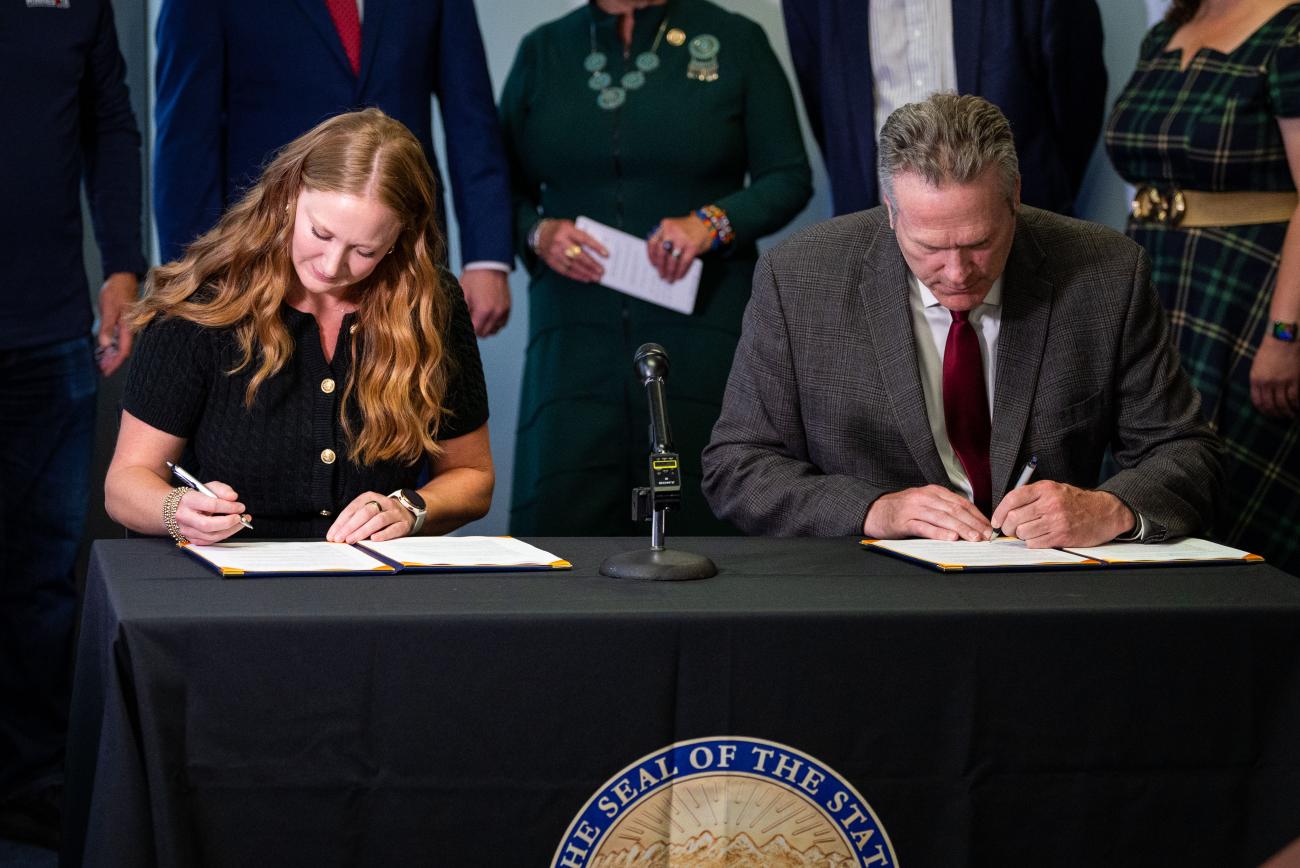 Director Emily Domenech and Alaska Governer Dunleavy signing the state MOU