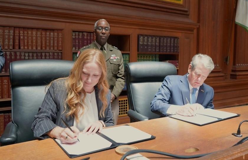 Executive Director Emily Domenech and Georgia Governor Brian Kemp signing their MOU copies
