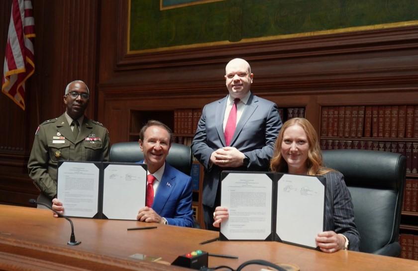 Executive Director Emily Domenech and Louisiana Governor Jeff Landry displaying their signed MOU copies