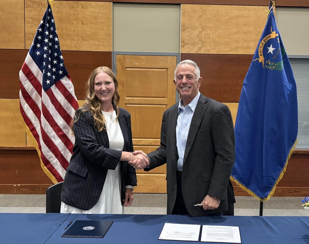 Executive Director Emily Domenech and Nevada Governor Joe Lombardo shaking hands after signing the MOU